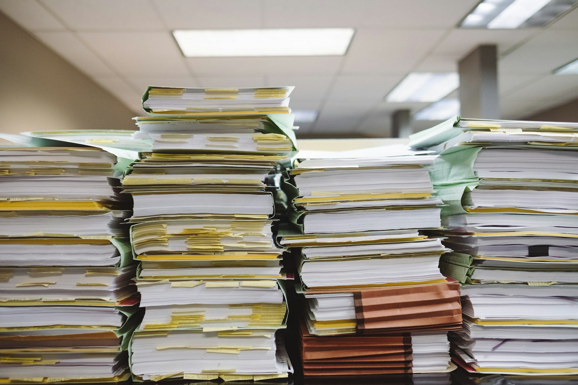 Stapel von Papierakten, mit Haftnotizen sortiert